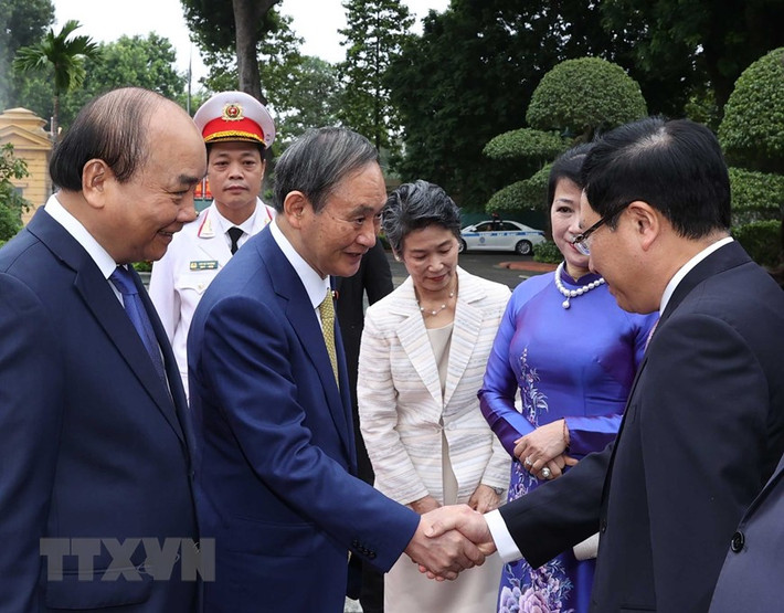 Thủ tướng Nhật Bản Suga Yoshihide với các thành viên chính thức Đoàn đại biểu Việt Nam tại Lễ đón. (Ảnh: Thống Nhất/TTXVN)