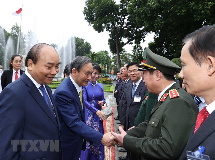 Thủ tướng Nhật Bản Suga Yoshihide với các thành viên chính thức Đoàn đại biểu Việt Nam tại Lễ đón. (Ảnh: Thống Nhất/TTXVN)