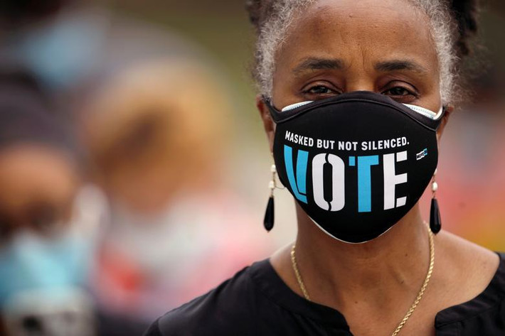Người phụ nữ đeo khẩu trang khi đi bỏ phiếu sớm tại Durham, North Carolina, ngày 15/10. Ảnh: Reuters.