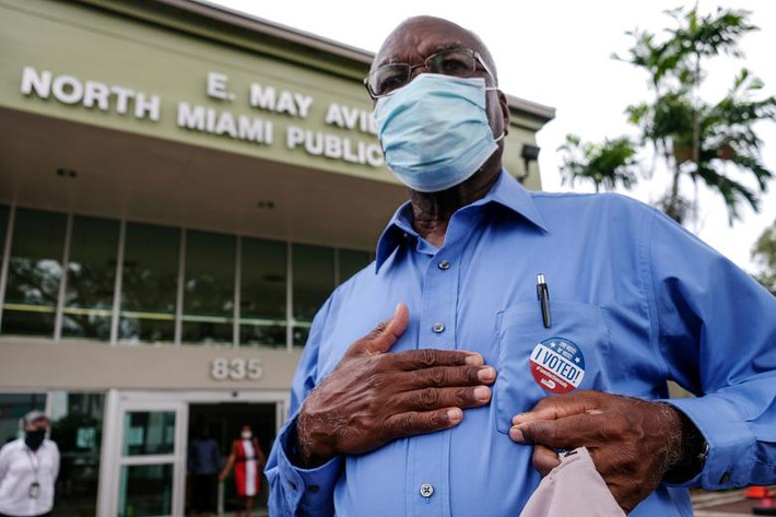 Wilner Rejouis rời khỏi điểm bỏ phiếu ở Miami, Florida, hôm 19/10. Ảnh: Reuters.