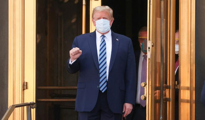 Ông Trump giơ tay hình nắm đấm thể hiện sự mạnh mẽ khi bước ra khỏi bệnh viện Walter Reed để lên trực thăng trở về Nhà Trắng hôm 5/10.