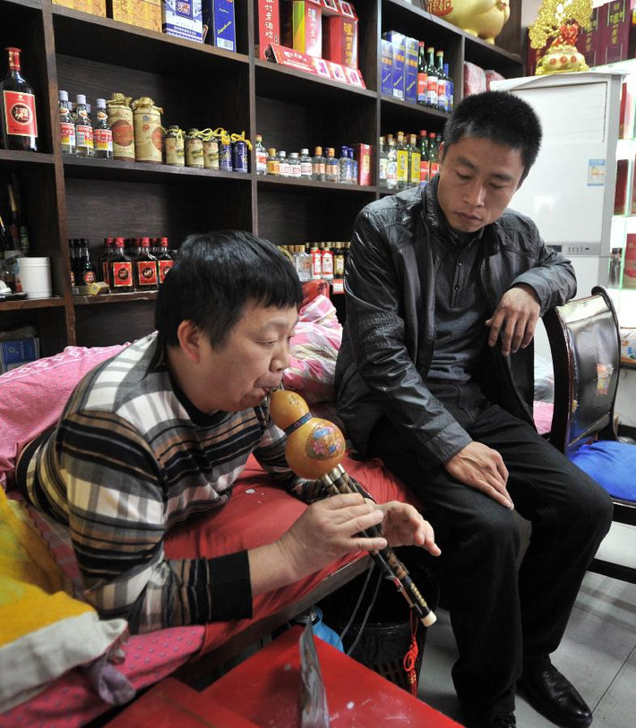 Những lúc rảnh rỗi, ông Peng chơi nhạc cho hàng xóm thưởng thức. Ảnh: Xinhua.