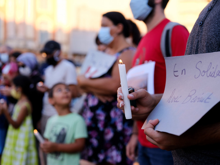 Người đàn ông cầm nến và tấm biển có dòng chữ "Đoàn kết với Beirut" trong buổi lễ được tổ chức tại Toulouse, Pháp.