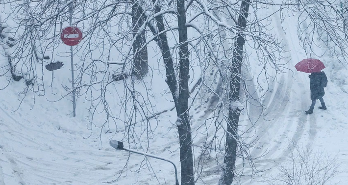 Một người cầm ô đi trên đường giữa tuyết rơi ở Kiev, Ukraine, ngày 1/12.