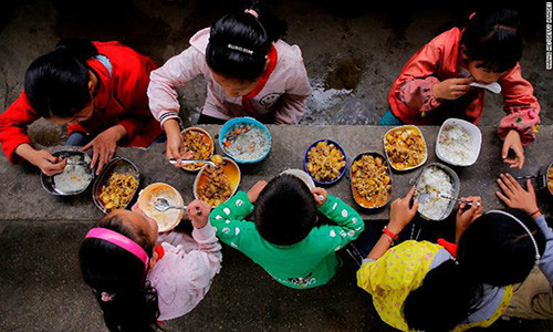 Học sinh ăn trưa miễn phí tại trưòng Yuanbao ở tỉnh Quý Châu, Tây Nam Trung Quốc. Bữa ăn gồm cơm và các món truyền thống.