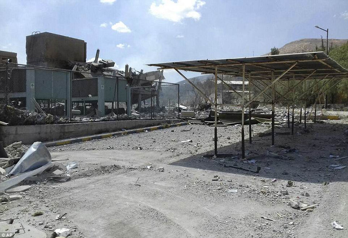 Đoạn video được chiếu trên kênh truyền hình Al-Ikhbariya (Syria) cho thấy đống đổ nát bên ngoài tòa nhà trung tâm bị phá hủy và chiếc xe bị đốt cháy. Ảnh: AP.