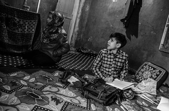 Sugra Sarjan và Aazaan Sarjan ngồi trong nhà ở huyện Shopian. Được biết, cha của hai em, Sarjan Barkati, đã bị bắt giam vào năm 2016 sau khi bài phát biểu có nội dung chống Ấn Độ của ông lan truyền trên mạng xã hội.