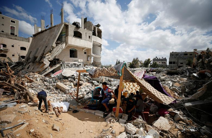 Người dân Palestine ngồi trong túp lều tạm bợ ở Gaza ngày 23/5.