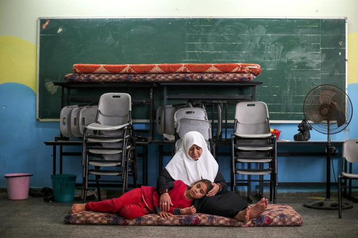 Người phụ nữ Palestine và bé gái ngồi nghỉ trong một phòng học tại ngôi trường được sử dụng làm nơi trú ẩn tạm thời ở thành phố Gaza hôm 15/5.