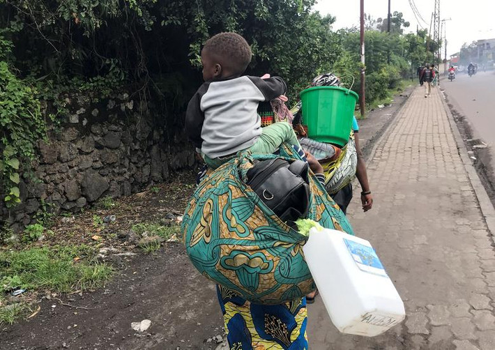 Người phụ nữ Congo cõng con và đồ đạc trên đường đi sơ tán gần Goma hôm 27/5.