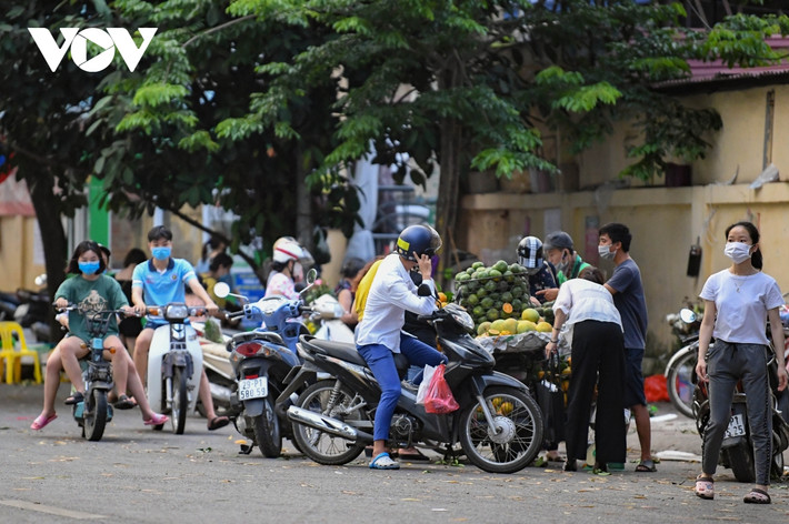 Tuy nhiên, vẫn còn một số địa bàn, dù lực lượng chức năng đã vào cuộc tuyên truyền, xử lý nhưng tình trạng họp chợ "cóc" vẫn diễn ra. Trong ảnh là một xe bán hoa quả rong trên đường Doãn Kế Thiện (phường Mai Dịch, quận Cầu Giấy, Hà Nội), rất nhiều người tập trung mua, bán.
