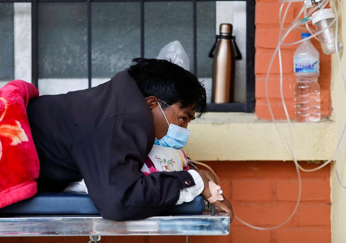 Một bệnh nhân thở oxy chờ bên ngoài bệnh viện do thiếu giường bệnh tại Kathmandu ngày 10/5.