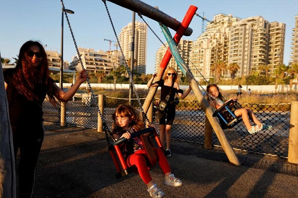 Các em nhỏ chơi xích đu tại một sân chơi ở Ashkelon, Israel, ngày 23/5, hai ngày sau khi Israel - Hamas đạt thỏa thuận ngừng bắn. (Nguồn ảnh: Reuters)