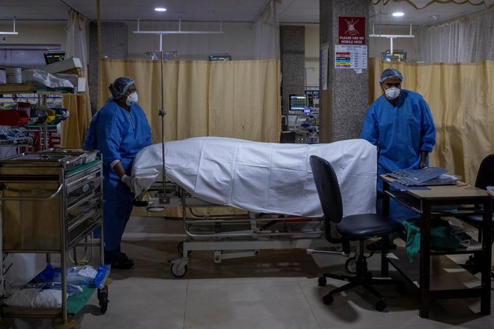 Nhân viên bệnh viện đưa thi thể bệnh nhân tử vong vì COVID-19 rời khỏi phòng ICU tại một bệnh viện ở thủ đô Ấn Độ.