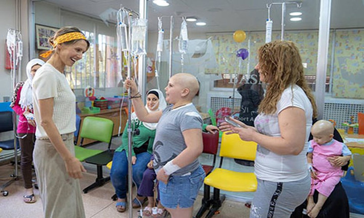 Trong thời gian điều trị căn bệnh ung thư, Đệ nhất phu nhân Syria Asma al-Assad vẫn dành thời gian đến thăm hỏi, động viên các em nhỏ mắc bệnh ung thư tại một bệnh viện nhi ở thủ đô Damascus nhân dịp lễ Eid al-Adha. Hành động của bà khiến nhiều người xúc động. Ảnh: AMN.