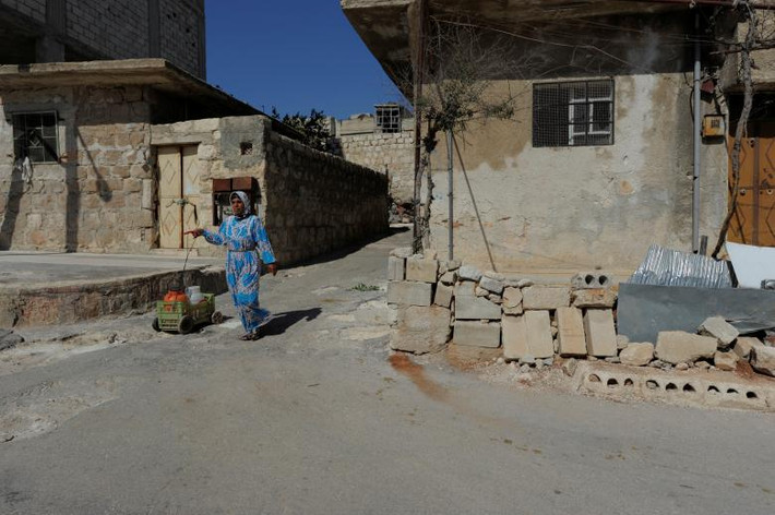 Người phụ nữ đi lấy nước ở khu Sheikh Maqsoud, Aleppo. (Nguồn ảnh: Reuters)