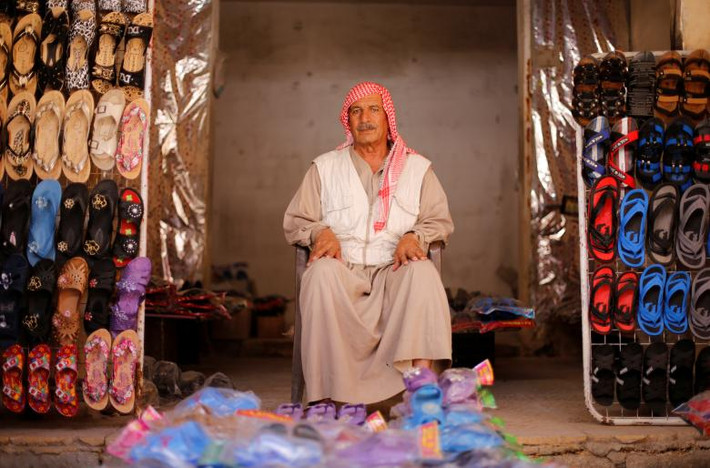 Người đàn ông bán giày dép ở quận người Kurd Sheikh Maqsoud.