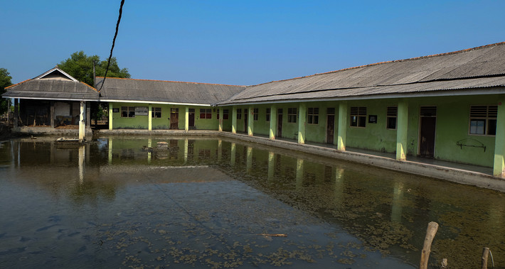 Nước ngập lênh láng tại sân một ngôi trường tiểu học ở làng Pantai Bahagia. Khi thủy triều dâng cao, nước tràn vào lớp học và nhà trường phải điều chỉnh thời gian học để tránh thời điểm ngập lụt. Ảnh: AJ.