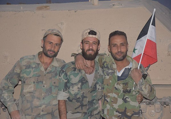 Được biết, lữ đoàn 105 và 106 của Vệ binh Cộng hòa Syria đã “chọc thủng” nhiều thành trì suốt 5 năm qua của nhóm phiến quân trong khu vực này. Ảnh: Các binh sĩ cầm lá cờ Syria mỉm cười trong một tòa nhà ở Damascus. (Nguồn: FNA)
