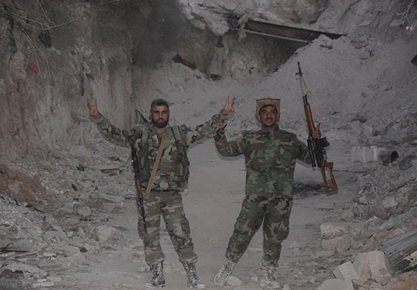 Hai binh sĩ Syria giơ tay biểu tượng chiến thắng trên chiến trường Đông Damascus. Ảnh: FNA.