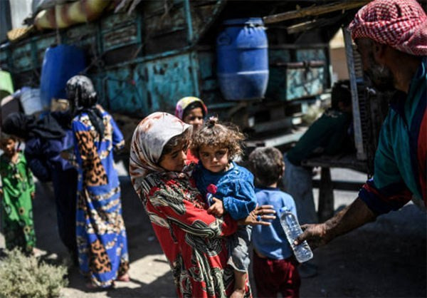 Nhiều em nhỏ theo gia đình sơ tán khỏi thành phố Raqqa. Ảnh: FNA.