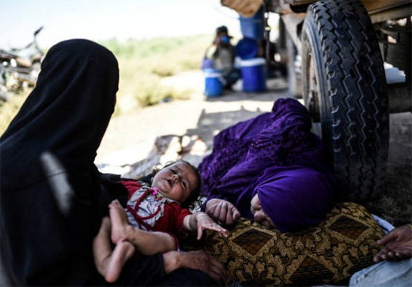 Mọi người tranh thủ nghỉ ngơi trên hành trình chạy loạn khỏi Raqqa, nơi được coi là “thủ phủ” của phiến quân IS tại Syria. Ảnh: FNA.