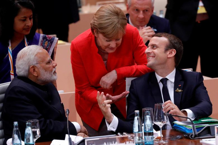 Tổng thống Pháp Macron trao đổi với Thủ tướng Merkel trong khi Thủ tướng Ấn Độ Narendra Modi ngồi cạnh lắng nghe.