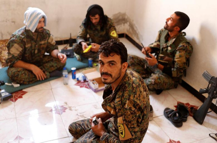 Các chiến binh YPG ngồi nghỉ trong ngôi nhà ở Raqqa. (Nguồn ảnh: Reuters)