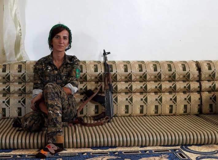 Nữ chiến binh người Kurd Sheen Ibrahim ngồi trong một ngôi nhà ở Raqqa.