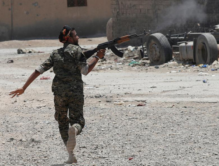 Chiến binh người Kurd ngắm bắn các tay súng IS trong lúc chạy qua một con phố ở Raqqa.