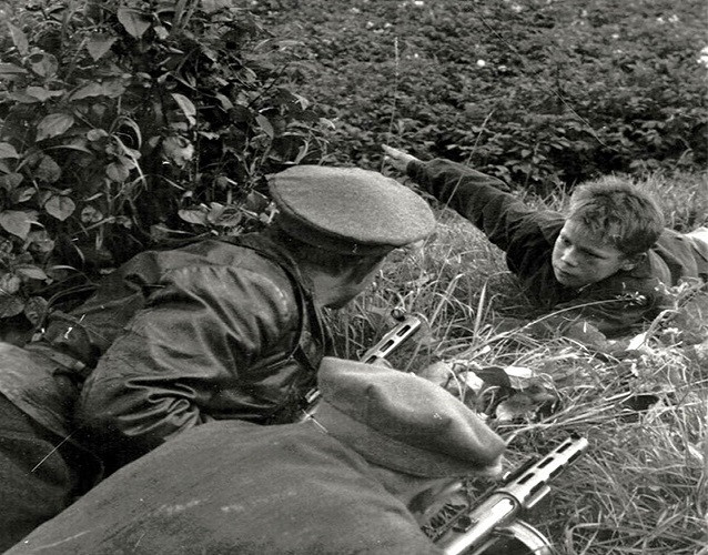 Một bé trai báo cho các binh sĩ biết vị trí của lính Đức Quốc xã năm 1943. Ảnh: VT.