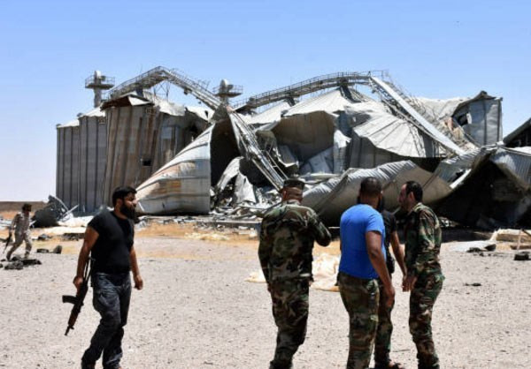 Các binh sĩ Syria đứng trước một công trình đổ nát sau các cuộc giao tranh ở tỉnh Raqqa. Ảnh: FNA.