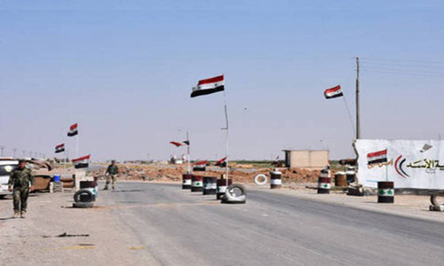 Những lá cờ Syria tung bay trên một con đường ở làng Khirbat al-Sa’ab. Ảnh: FNA.