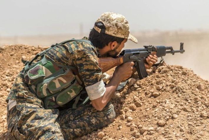 Một chiến binh người Kurd ngắm bắn phiến quân IS ở vùng ngoại ô Raqqa. Ảnh: AMN.