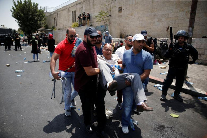 Người dân Palestine đưa một người bị thương trong cuộc đụng độ với lực lượng an ninh Israel đi chữa trị.