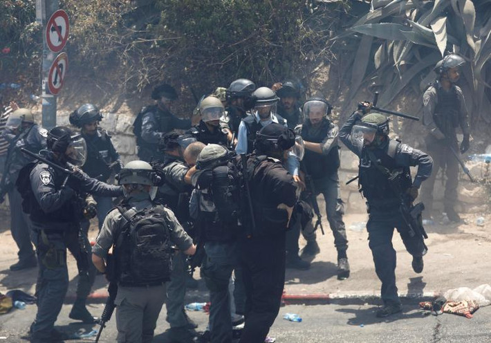 Cảnh sát biên giới Israel bắt giữ một người đàn ông Palestine.