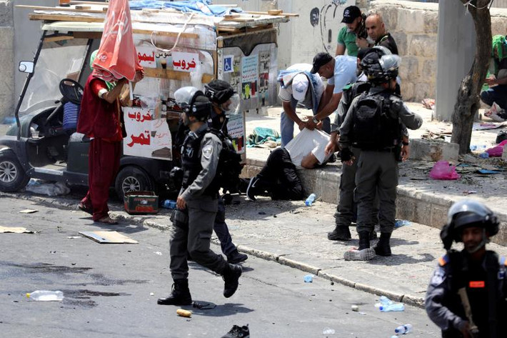 Lực lượng an ninh Israel bắt giữ một người Palestine sau cuộc đụng độ bên ngoài Thành phố cổ Jerusalem.