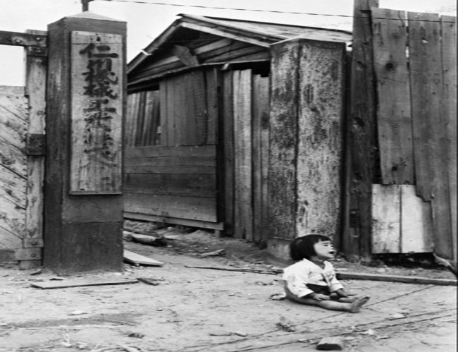 Một em nhỏ bị bỏ rơi ngồi khóc trên đường phố Incheon, Hàn Quốc, hồi tháng 9/1950. Ảnh: CNN.