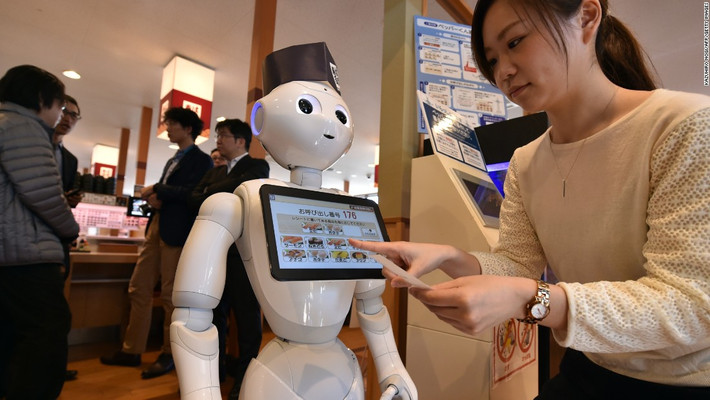 Robot Pepper làm việc tại Hamazushi, một chuỗi nhà hàng sushi ở Nhật Bản. Pepper sẽ đặt chỗ ngồi, dẫn khách hàng đến bàn của họ. Thực khách có thể chọn món ăn trong “menu” hiện lên màn hình máy tính gắn trên ngực robot. Ảnh: CNN.