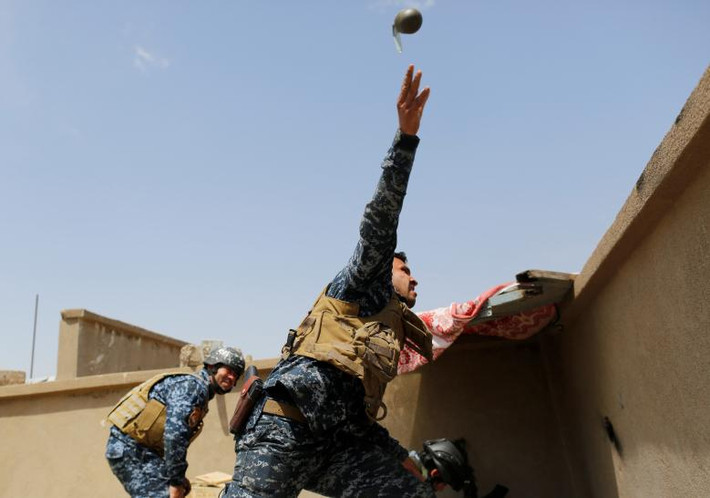 Cảnh sát Iraq ném lựu đạn cầm tay trong cuộc giao tranh với IS ở Tây Mosul hồi tháng 4/2017.