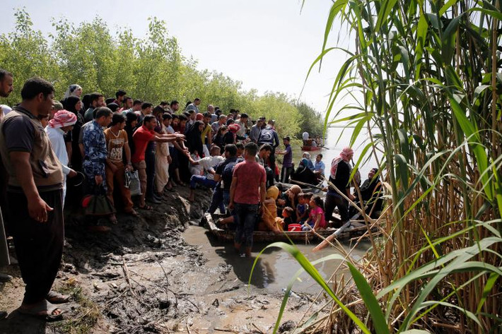 Những người dân Iraq sơ tán chờ qua sông Tigris tại ngôi làng Thibaniya, phía nam Mosul, tháng 5/2017.