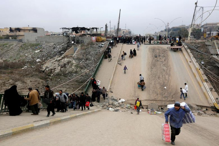 Những người dân Iraq chạy loạn đi qua cây cầu ở khu Al-Muthanna vào tháng 1/2017.