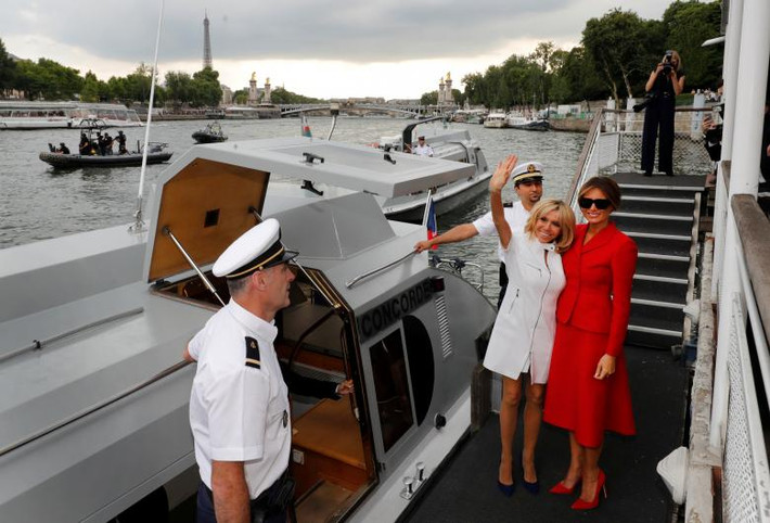 Bà Brigitte Macron vẫy tay chào khi đứng cạnh Đệ nhất phu nhân Mỹ Melania sau khi đi thuyền trên sông Seine ở Paris.