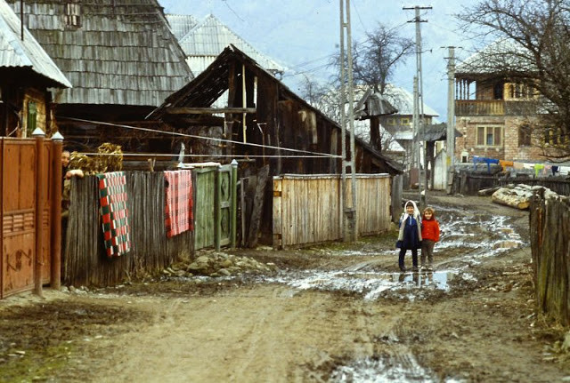 Hai em nhỏ đi qua con đường lầy lội ở Romania. Ảnh: VT.