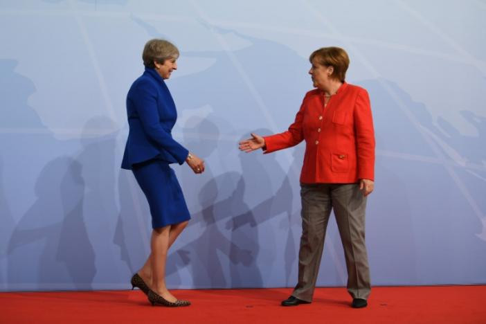 Thủ tướng Anh Theresa May lại gần bắt tay Thủ tướng Đức Merkel ở Hamburg ngày 7/7.