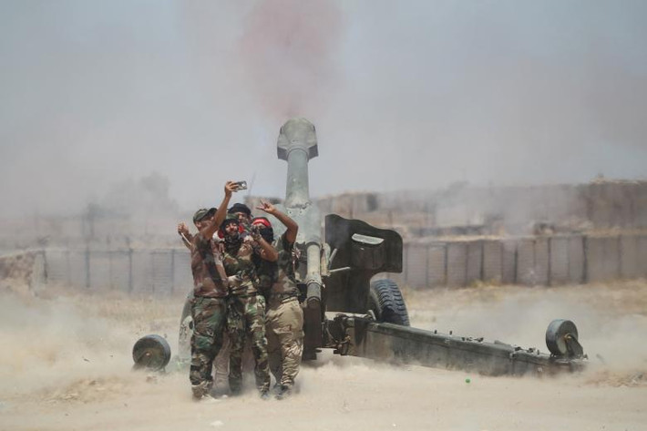 Các chiến binh Shiite chụp ảnh sau khi nã pháo về phía căn cứ của nhóm IS gần Fallujah, Iraq, hôm 29/5/2016. (Nguồn ảnh: Reuters)