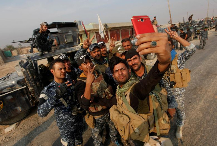 Các cảnh sát Iraq giơ tay biểu tượng chiến thắng trong bức ảnh chụp tại Qayyara, phía nam thành phố Mosul, ngày 26/10/2016.