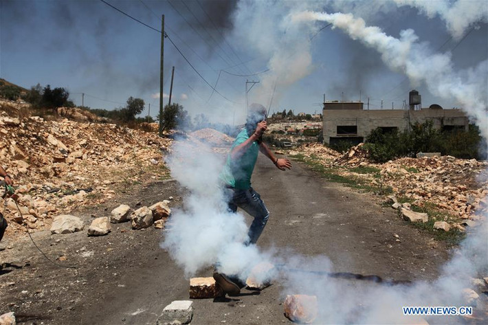 Người biểu tình Palestine quăng bình hơi cay về phía các binh sĩ Israel ở Kufr Qadoom hôm 23/6. Ảnh: THX.