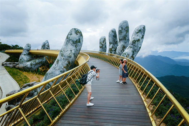 Khi nhìn cây cầu Thái Hồng Tiên Thủ mới được khai trương tại Trung Quốc, người ta dễ dàng nhận thấy cây cầu này có vẻ ngoài khá tương đồng với Cầu Vàng nổi tiếng của Việt Nam. Cầu Vàng của Việt Nam dài 150 m và nằm ở độ cao 1.400 mét so với mực nước bển trên núi Bà Nà. Cầu được mở cửa từ tháng 6/2018 và là một trong những điểm du lịch hút khách hàng đầu tại thành phố Đà Nẵng. Ảnh: Zing.vn.