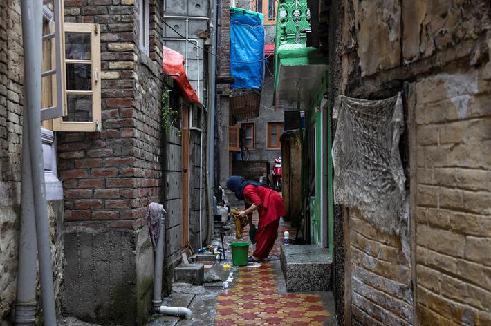 Người phụ nữ Kashmir giặt đồ trong thời gian nơi này bị áp đặt lệnh giới nghiêm.